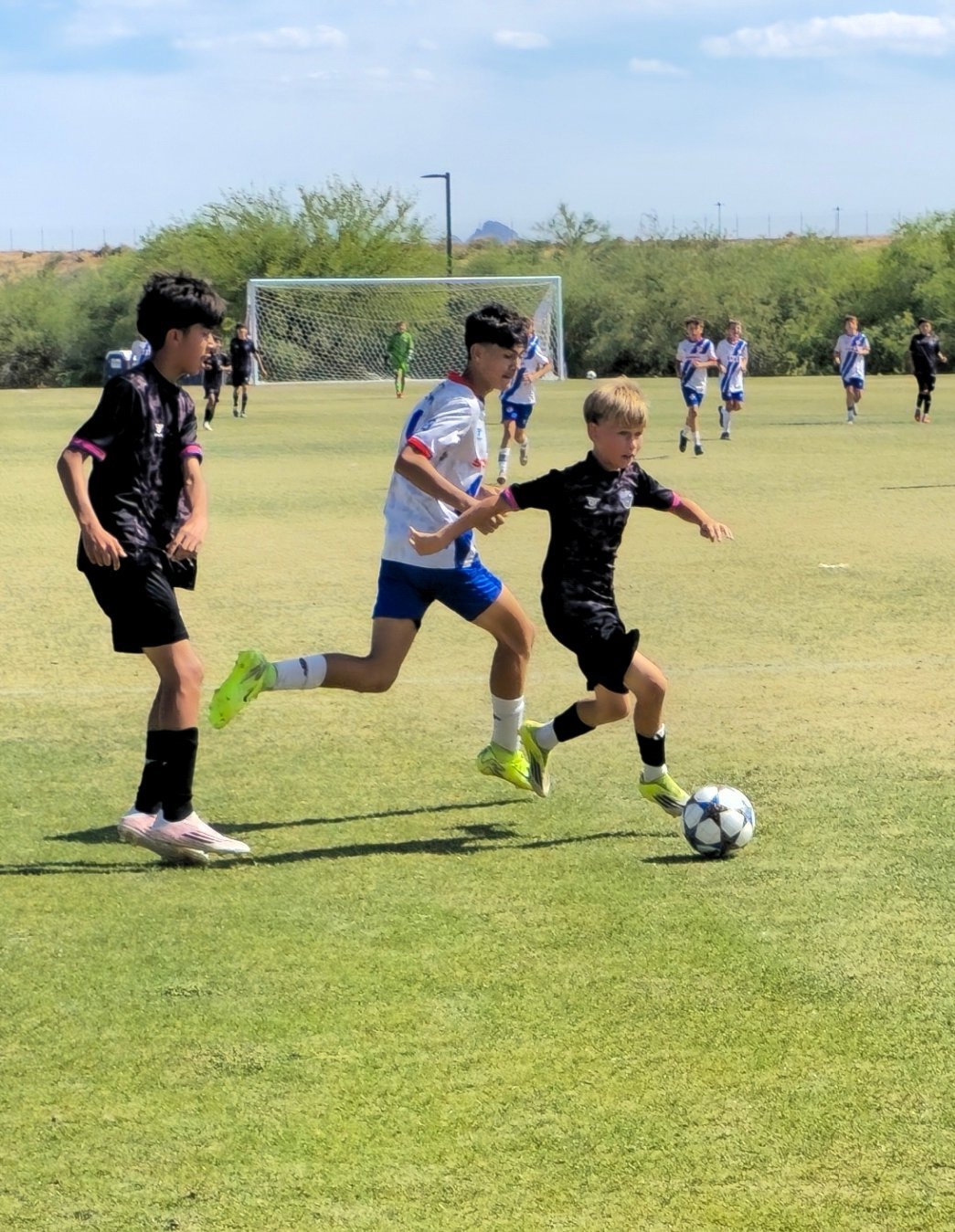 Youth soccer players competing in a match on a grass field